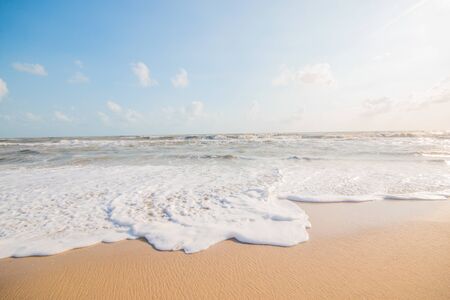 Sea water bubble at the beach and beautiful wave in background.の写真素材