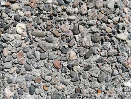 Stone pattern wall with lots of pebbles in different colors, patterns and texturesの写真素材