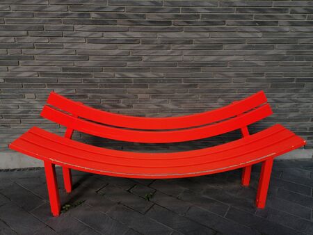 Colorful bench forming a smiling face with brick wall backgroundの写真素材