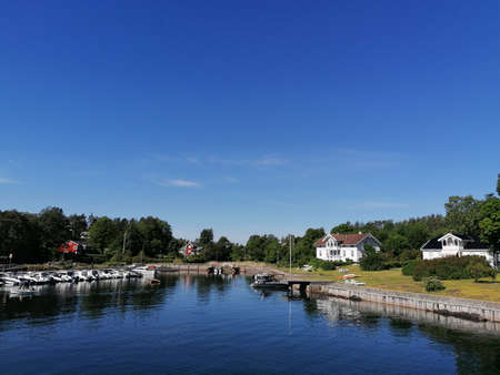 houses and small boats on an island in the ocean on a summer dayの写真素材