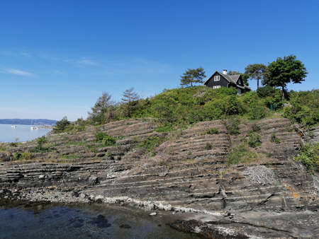 cottage on a hill on an island in the oceanの写真素材