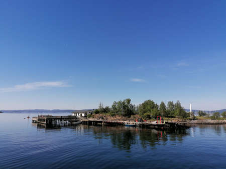 Small boats and an island on the lake on a beautiful summer dayの写真素材