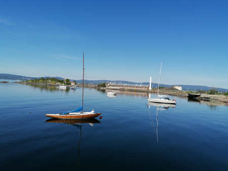 Small boats and an island on the lake on a beautiful summer dayの写真素材