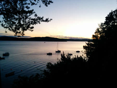 sunset on the sea with small boatsの写真素材