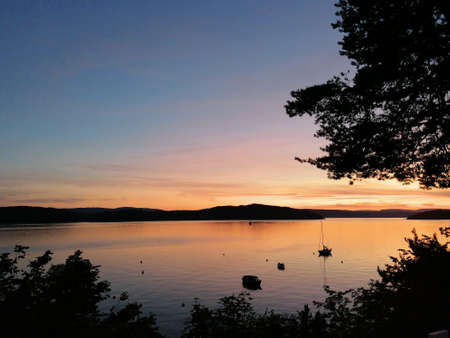 sunset over the lake with small boats and beautiful colorsの写真素材