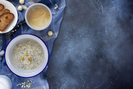 oatmeal porridge with Chia seeds and raisins, coffee and pastries on a dark blue background with copy spaceの写真素材