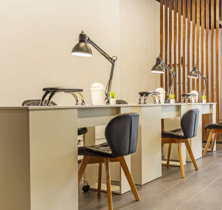 Manicure tables with lamps and cozy chairs in the barbershopの写真素材