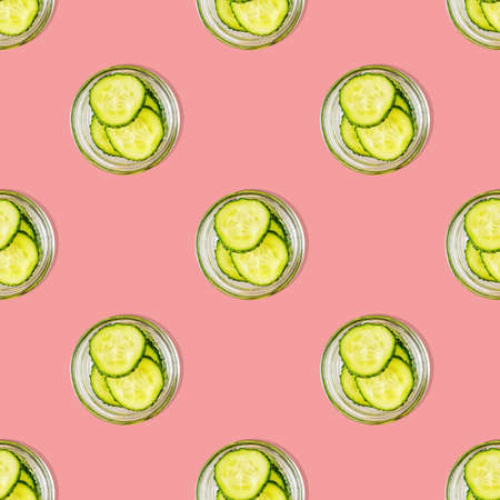 Seamless pattern of cucumber slices on a pink background. Photo collage. Food, cosmetics blog, vegetable background. Ingredients for home skin care. Printing on fabric, wrapping paper. Top viewの写真素材