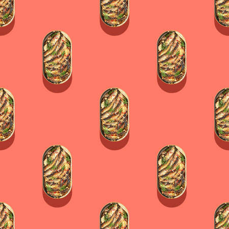 Seamless pattern with isolated open tin of Baltic sprats in oil with spices on a pink background. Snack - sea smoked fish. The concept of simple healthy food. Top viewの写真素材