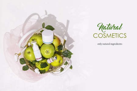 Cosmetic composition with green apples, bottles with cream and beauty accessories on a white background with easy removable sample text. Healthy, summer, natural cosmetics. Anti-aging treatmentsの写真素材