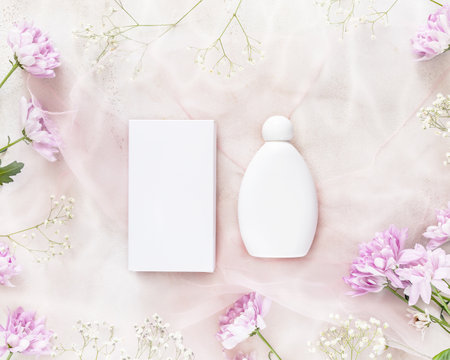 Natural skin care product concept. Mock up for cosmetics based on natural ingredients on a light pink, flower background. Spring composition with white, beauty mock-up bottles for brandingの写真素材