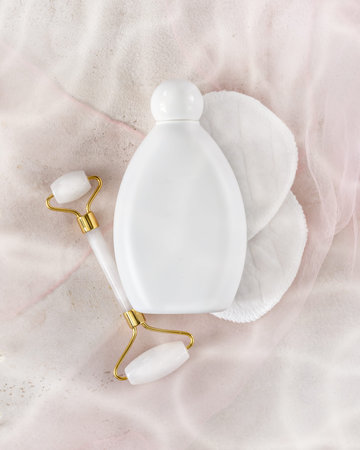 Natural skin care product concept. Flat lay mock up for moisturizing cosmetics on a light pink background with water glare. Spring composition with white, beauty mock-up bottle for branding and labelの写真素材