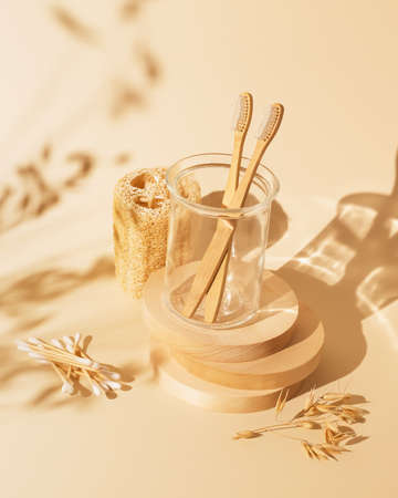 Ecological, spa composition of a family set of two eco friendly, wooden, bamboo toothbrushes, wooden cotton swabs and washcloth. Concept of zero waste, no plastic. Eco friendly bathroom still lifeの写真素材