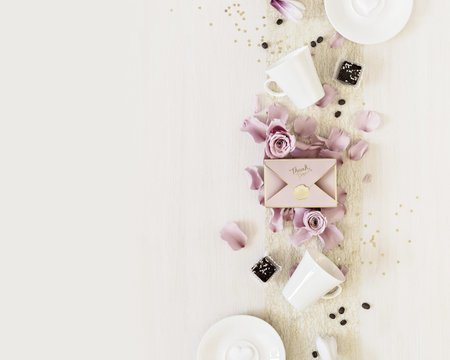 Holiday coffee concept. Romantic morning still life with cups of coffee, sweets, a gift box and rose...