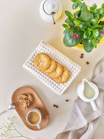 Morning composition with a kalanchoe flower, a cup of coffee and handmade cookies. Breakfast with a houseplant and a cup of espresso. Plant parent concept, relaxing at home, handmade low carb bakingの写真素材