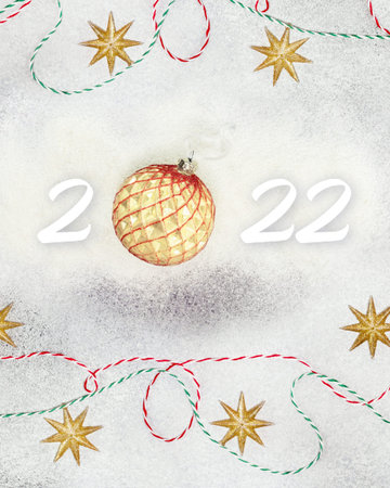 Happy New Year 2022. White numbers with a New Year 's ball, ribbons and gold stars on a white...