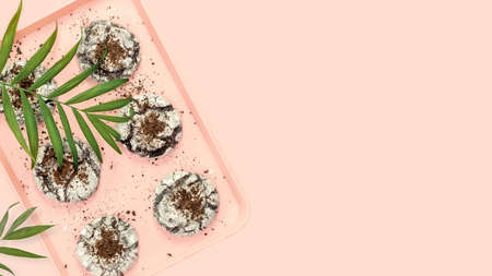 Natural home made brownie cookies. Food banner with hande made chocolate cookies on a pink tray with palm leaves on a pink background with copy space. Sweet homemade pastriesの写真素材