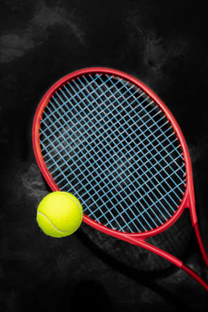 Yellow tennis ball with red racket on a black backgroundの写真素材