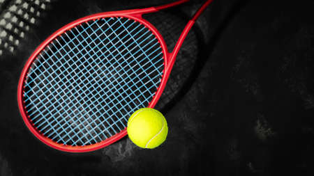 Tennis. Selected focus, sport composition with yellow tennis ball and red racket on a black textured background with copy space. The concept of tennis competitionsの写真素材