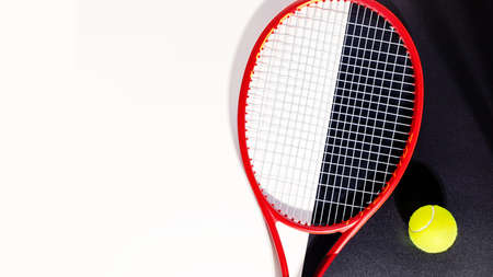 Tennis banner. Sport composition with a tennis racket and a ball on a black and white background with copy space. Sport and healthy lifestyle. The concept of outdoor game sportsの写真素材