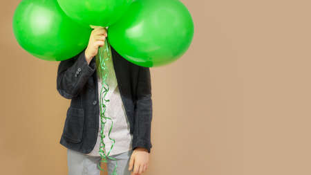 School boy with green balloons on a craft backgroundの写真素材