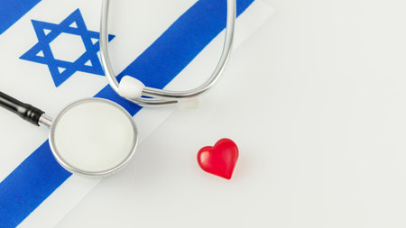 Concept of medicine in Israel. Medicine banner with stethoscope, Israel flag and decorative heart on a white background with copy space. Professional surgery in Israelの写真素材