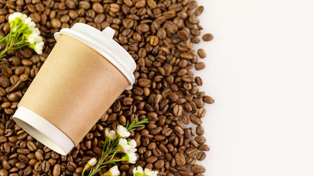Coffee to go banner. Disposable eco-friendly cardboard cup on a natural coffee beans with flowers...