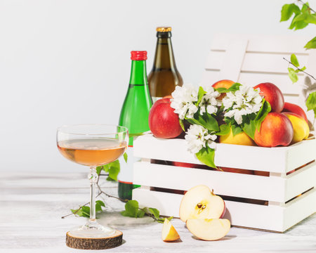 A Glass of natural apple cider with bottles and farm applesの写真素材