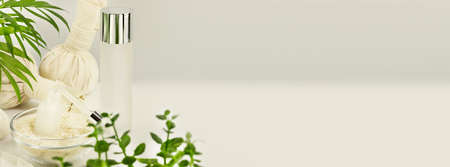 Fermented beauty care. Cosmetic banner with organic rice serum and rice water in a glass bowl on a white table with palm leaf and copy space. natural cosmetics based on fermented productの写真素材