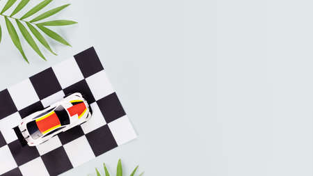 Racing competition banner. Car rally flag with sport car and palm leaves on a blue background with copy space. Car race, sport card, flat lay. motocross backgroundの写真素材