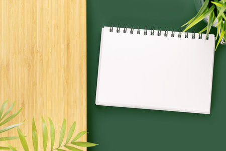 Eco friendly, natural background. Green table with notebook with white blank sheet for your text and...