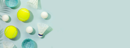Summer sport activities banner with tennis balls, table tennis balls and shuttlecocks on blue background with palm shadows. Healthy lifestyle. Tennis, table tennis, badminton. Banner size, copy spaceの写真素材
