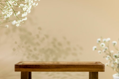Wooden empty podium for food, products or cosmetics on natural beige background with white flowers and shadows. Scene stage showcase for product, promotion sale or advertising. Front viewの写真素材