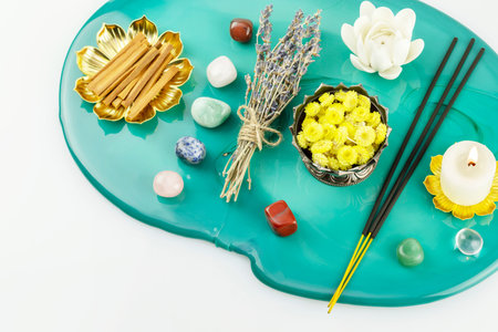 Self-care, healing composition with candle, aroma sticks, chakra stones, sandalwood sticks and dry flowers on green marble podium. Concept of relaxing at home, energy healing, meditation and me timeの写真素材