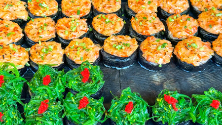 Vibrant display of Asian street food presents spicy tuna rolls with delicate garnishes and seaweed...