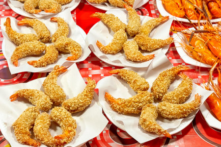 Breaded shrimp creatively displayed on plates at a street food market, catering to the fast food trend with a gourmet twist for seafood loversの写真素材