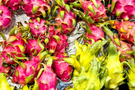 Fruit backdrop with vivid pink and yellow dragon fruit at a market, their striking colors and shapes emphasizing their role in the visual feast of modern, exotic fruit trends. Healthy foodの写真素材