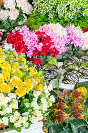 Colorful array of flowers, including begonias, roses, and hydrangeas, is beautifully arranged in flower shop. Inviting small business atmosphere. Floral backdrop. Vertical formatの写真素材