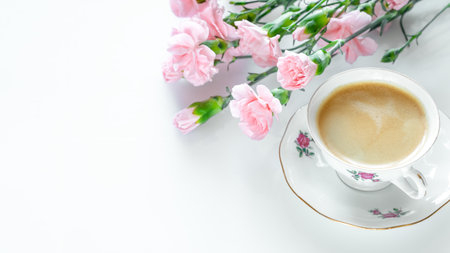 Delicate pink flowers and vintage teacup filled with coffeeの写真素材