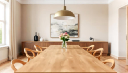 Elegant dining room with large wooden table, modern chairs, and brass pendant light, set in soft neutral tones. Perfect blurred background for interior design, furniture, or decor-related projectsの素材