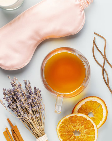 Self-care flat lay with sleeping mask, lavender flower, herbal tea, dry oranges and aroma sticks on a blue background. Concept of Me time and no depression. Healthy sleep is healthy lifeの写真素材
