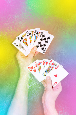 Playing Cards In Hands Against Vibrant Rainbow Gradient Background. Concept of Casino Night Party,...