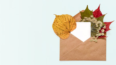 Autumn Envelope Mockup with Blank Card, Dried Leaves, and Wildflowers on Soft Blue Background with Copy Space, for Fall Greetings, Seasonal Stationery, Thanksgiving Posts, Harvest Festival Invitations