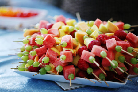 a plate of fruit kebabs at a partyの写真素材