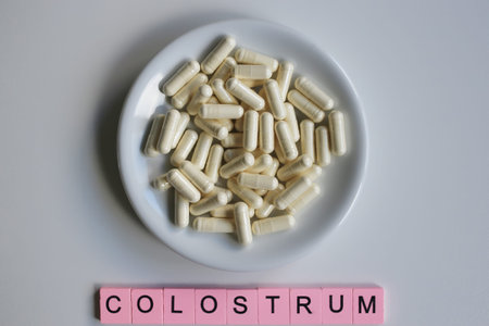 Pills capsules with colostrum, on a white background