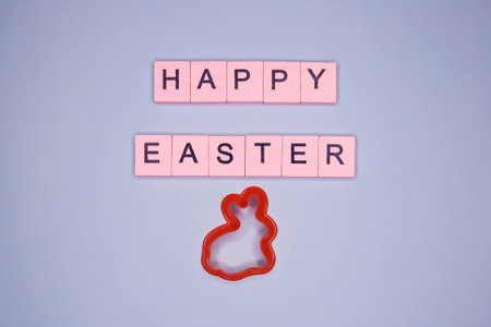 Happy Easter text made of wooden cubes on blue background. flat lay.の写真素材