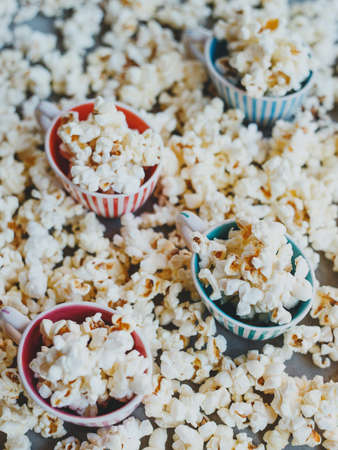 Salted popcorn in multi-colored cupsの写真素材