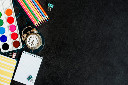 Back to school. School supplies on a black background. Top view. Copy space.