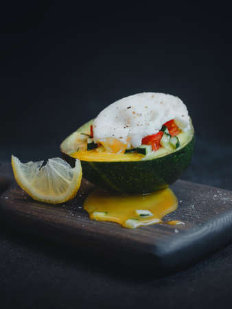 Avocado with poached egg and tomato and cucumber salad. Healthy food concept.の写真素材