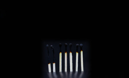 matches that was just put out, isolated on black background. row of burnt matches, from almost whole...
